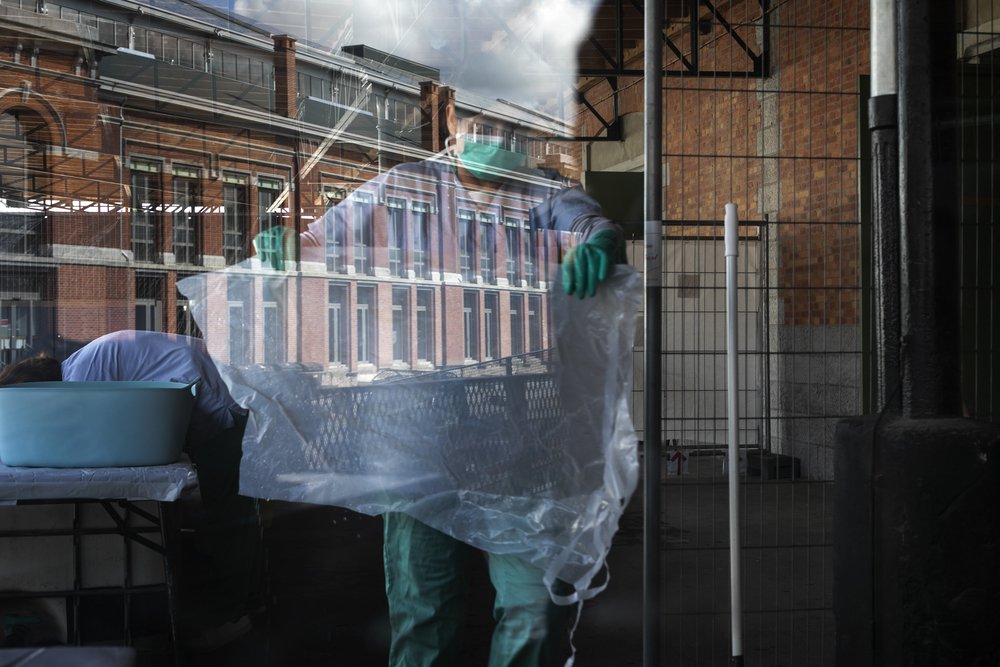Sara staat in de was en desinfectieruimte voor beschermende kleding van ons coronaproject in Brussel, België © Albert Masias/MSF