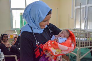 Kinderarts met baby in moeder- en kindziekenhuis