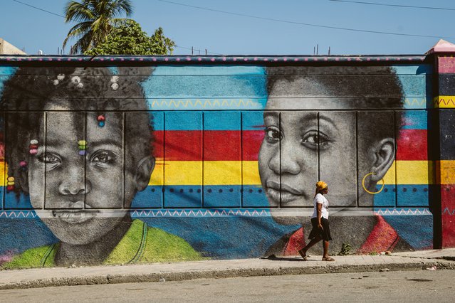 Een vrouw loopt langs een muurschildering in Bois-Verna, een woonwijk in Port-au-Prince. © Valerie Baeriswyl