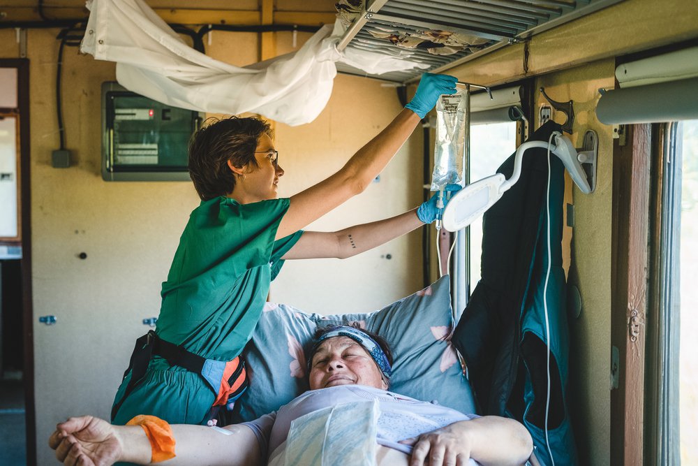 Verpleegkundige Anastasia behandeld onze patiënt in de medische trein
