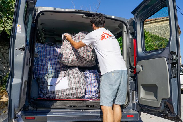 Een hulpverlener van Artsen zonder Grenzen laadt de auto in met kits voor medische noodhulp.