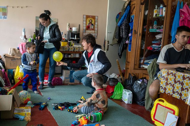 Viktoria (24) vluchtte met haar twee zoons uit Oost-Oekraïne. In de opvanglocatie speelt onze coördinator Paulo met de kinderen. © Jose Colon Toscano