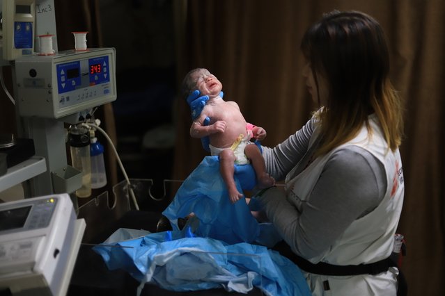 manager verloskunde houdt baby in de lucht in gaza