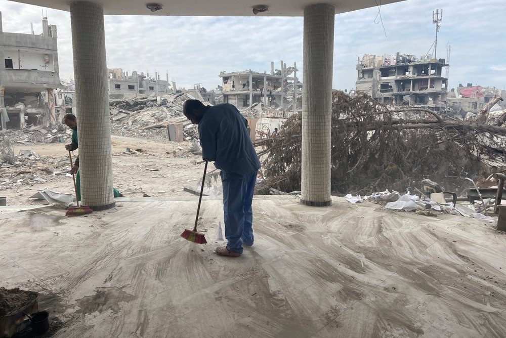 man veegt puin weg in Gaza