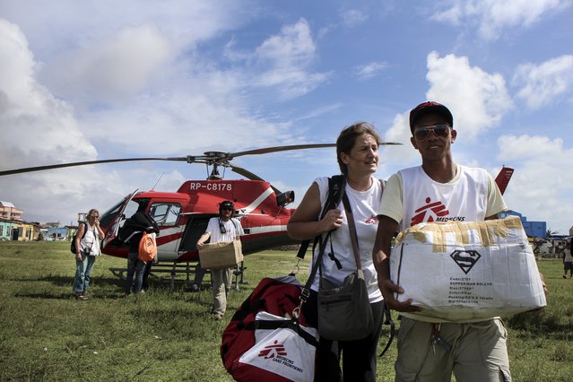 Hulpverleners op de Filipijnen laden spullen uit de helikopter.