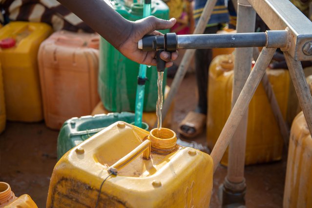 Water wordt op een centraal distributiepunt in jerrycans gedaan in Djibo, Burkina Faso. ©Mack Alix Mushitsi
