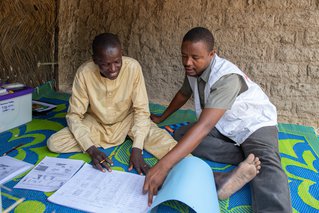 Verpleegkundige Malik (rechts) helpt vrijwilliger Kader (links). Samen kijken ze welke middelen en medicijnen nodig zijn. ©Mack Alix Mushitsi/MSF