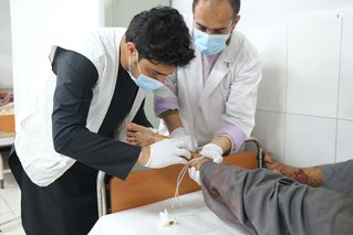 Supervisor Masood behandelt een patiënt aan een schotwond in het Boost-ziekenhuis. Provincie Helmand, Afghanistan