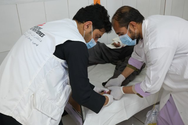 Eerstehulp coördinator Masood en een arts behandelen een man met een schotwond in zijn been. ©MSF/Tom