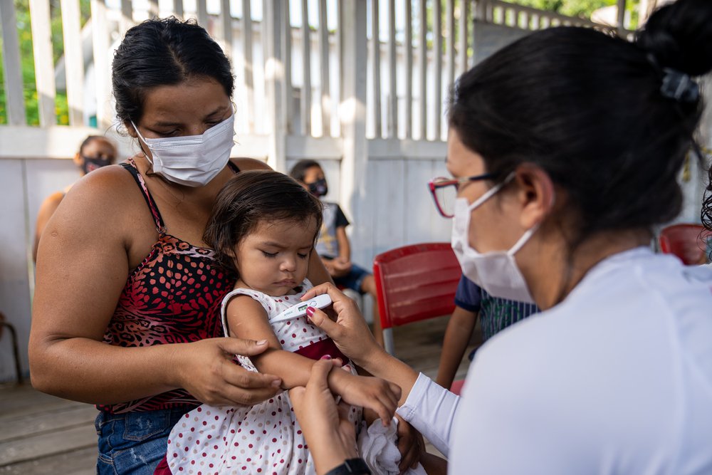 Verpleegkundige Artsen zonder Grenzen behandelt kind in Brazilië tijdens de corona pandemie.