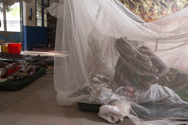 Een vrouw ligt met haar pasgeboren kindje onder een muskietennet in Leer, Zuid-Sudan