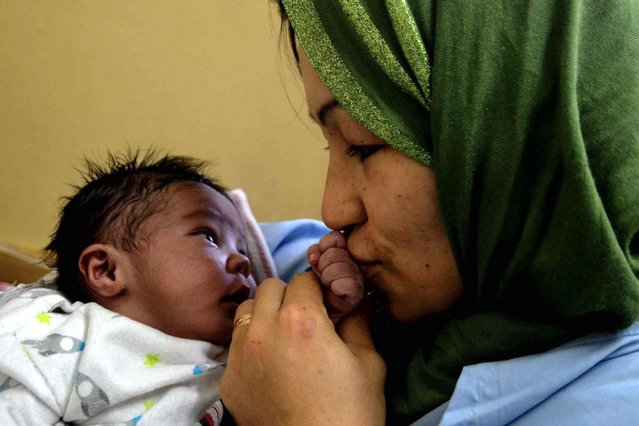Een trotse moeder kust de hand van haar kindje in het Dasht-e-Barchi-ziekenhuis in Kabul.