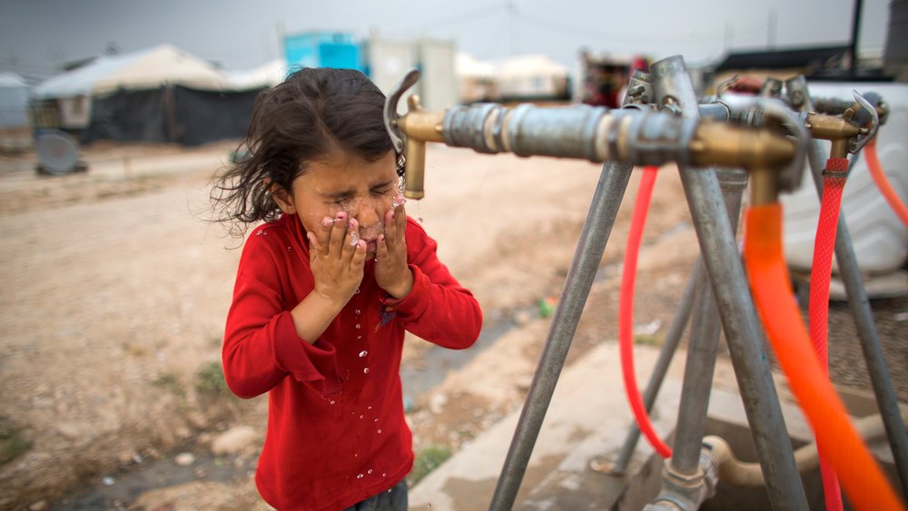 Een meisje drinkt schoon drinkwater in Khanaqin, Irak