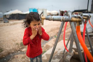 Een meisje drinkt schoon drinkwater in Khanaqin, Irak
