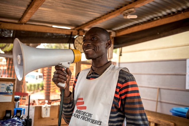 Een hulpverlener roept de ouders van een patiënt. Hij staat voor het  Bangui-ziekenhuis in CAR.