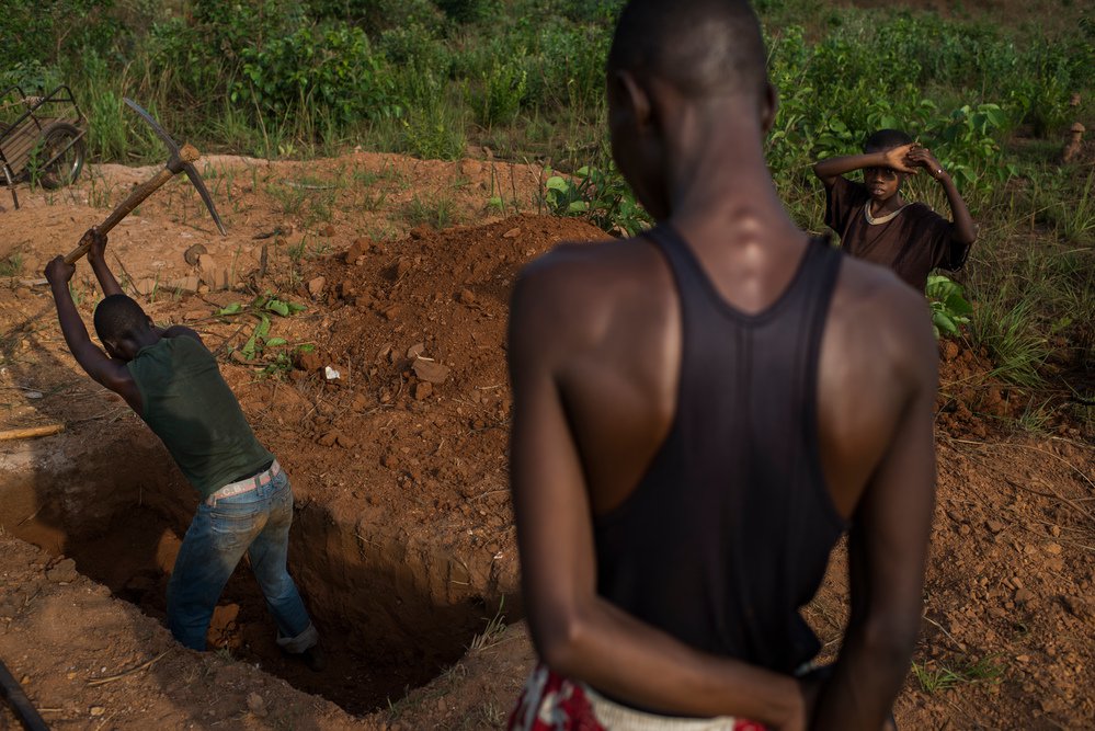 Jonge mannen graven een graf voor een omgekomen vriend in Bambari, Centraal Afrikaanse Republiek.