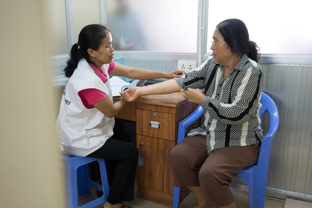Verpleegkundige Van Sokha meet de bloeddruk van de 61-jarige patiënt Nov Sokah.
