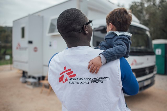Hulpverlener Artsen zonder Grenzen met kind op Lesbos, Griekenland