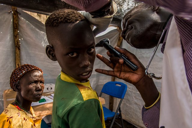 Verpleegkundige Artsen zonder Grezen onderzoekt het oor van een jonge patiënt in Zuid-Sudan