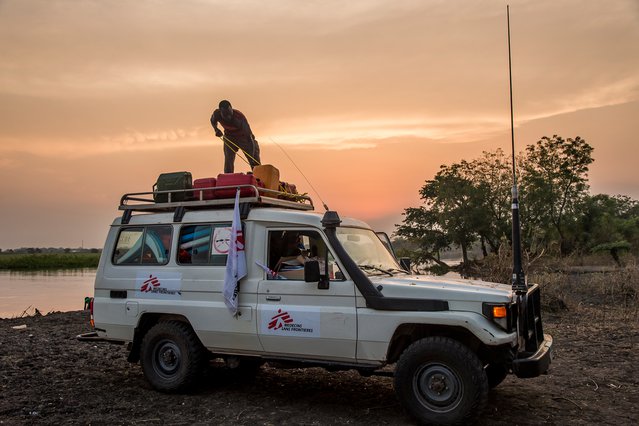 Medewerker Artsen zonder Grenzen bevestigt materialen op onze auto. Zuid-Sudan