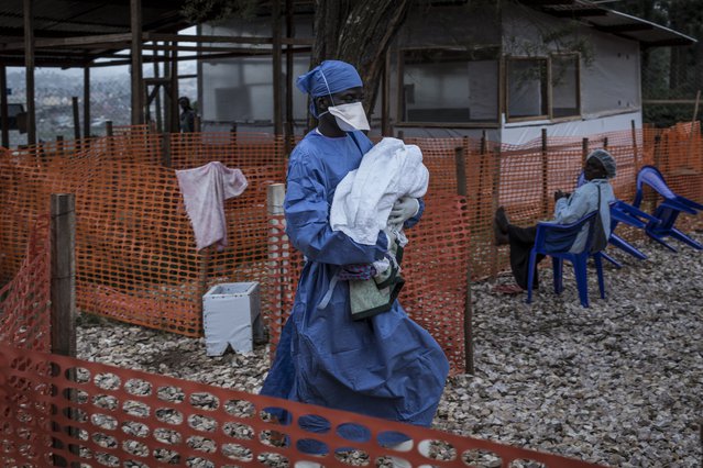 Een verzorger met een jonge ebolapatiënt in DR Congo.