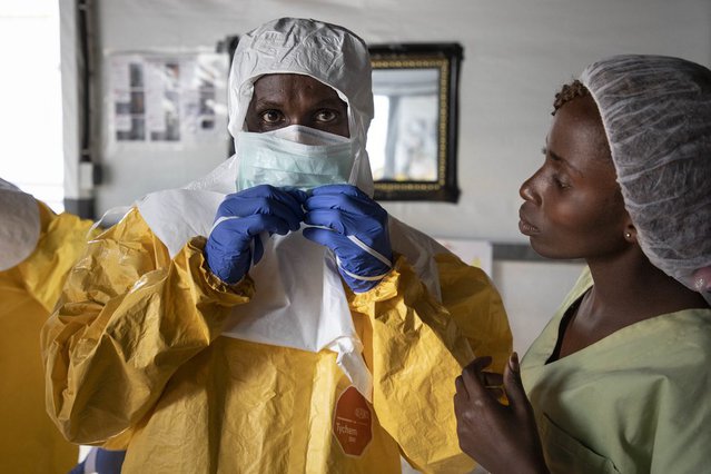 Hulpverlener Artsen zonder Grenzen trekt zijn ebola pak aan, DR Congo