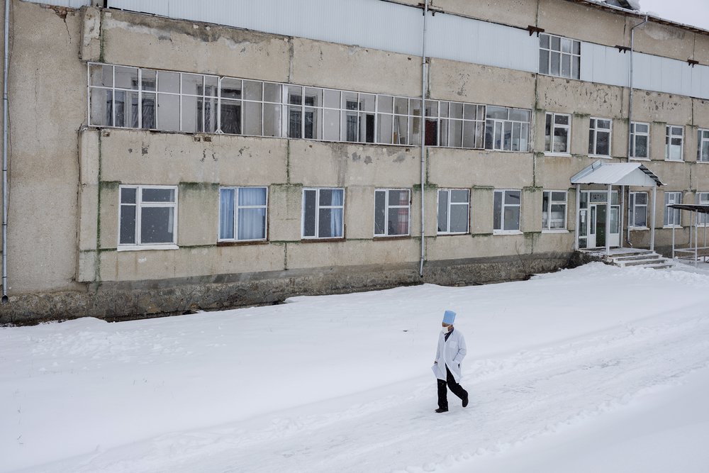 Een arts loopt langs het Aydarken-ziekenhuis in Kadamjay, Kyrgyzstan.