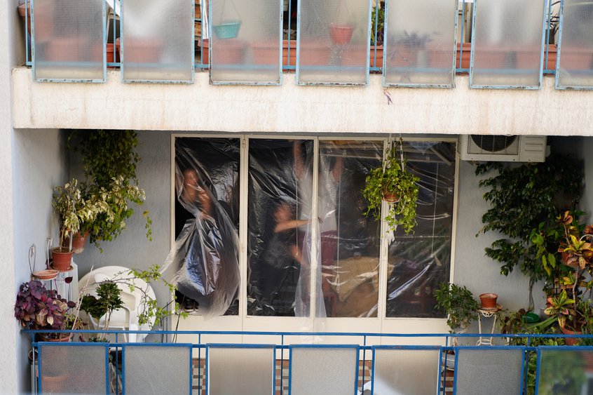 Bewoners bedekken hun ramen met plastic zeilen. Duizenden appartementen en winkels raakten beschadigd door de explosie waardoor de glazen ramen en hou