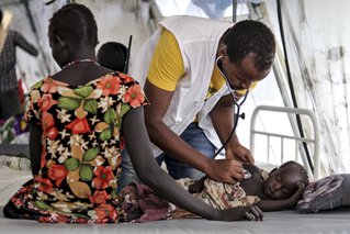 Een medewerker van Artsen zonder Grenzen onderzoekt een kind in de kliniek in Pibor, Zuid-Soedan.