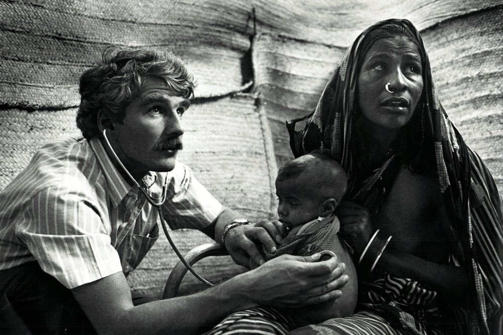 Dr. Francis Charhon onderzoekt het kind van een jonge vrouw in kamp Faw. © Sebastiao Salgado
