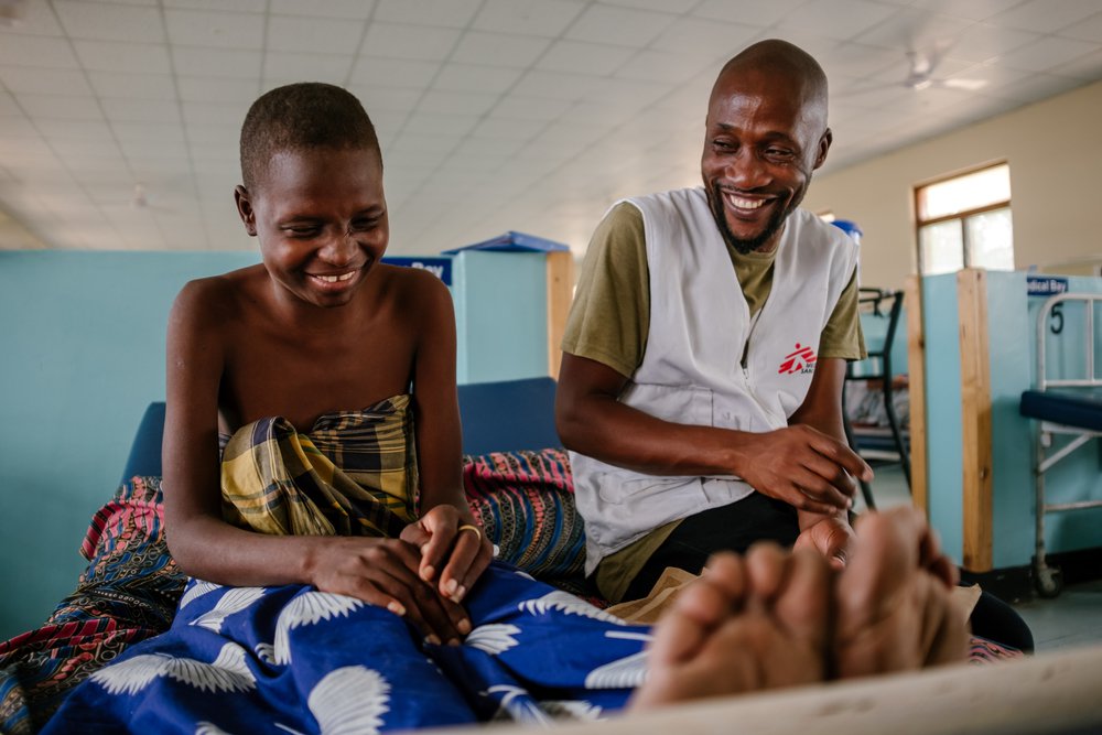 Foto: Moses Luhanga, medewerker Artsen zonder Grenzen met hiv-patient in ziekenhuis. © Isabel Corthier/MSF