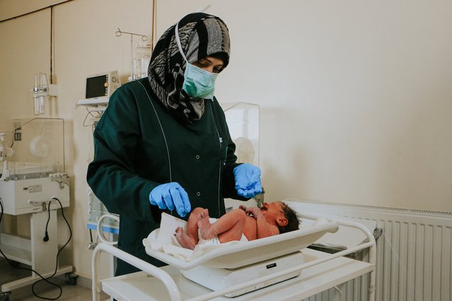 Hulpverlener van Artsen zonder Grenzen controleert het gewicht van een baby in het ziekenhuis in Idlib, Noordwest-Syrië