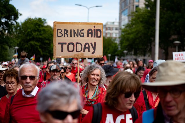 Tijdens de demonstrate Rode Lijn op 15 juni 2025 houdt iemand een bord omhoog dat zegt: bring aid today