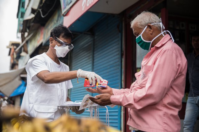 Gezondheidsvoorlichter deelt zeep en mondmaskers uit in Mumbai, India.