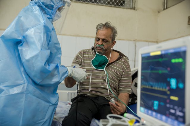 Arts behandelt patiënt in coronabehandelcentrum in India.