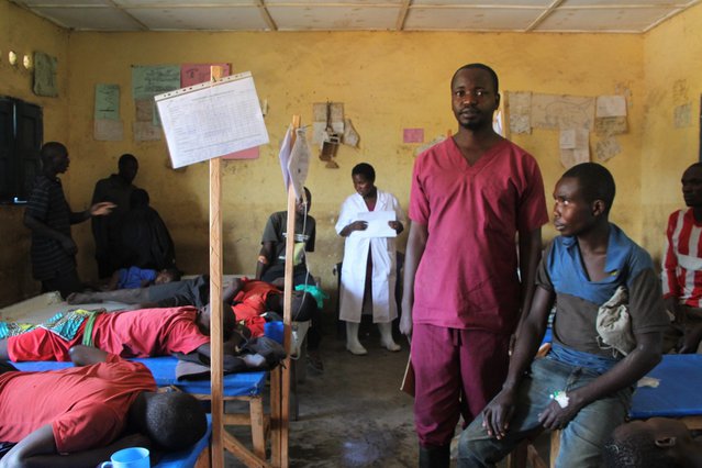 De eenendertigjarige Jimmy zit op een bed in het cholerabehandelcentrum van Artsen zonder Grenzen. Arts Laurent staat naast hem.