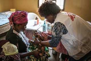 In een dorpskliniek in Sierra Leone onderzoekt Artsen zonder Grenzen verpleegkundige Ellen de 1-maand oude baby Fatmata.