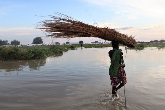vrouw waadt door water overstromingen zuid-soedan