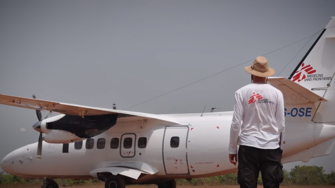 Medewerker Artsen zonder Grenzen kijkt naar vliegtuig